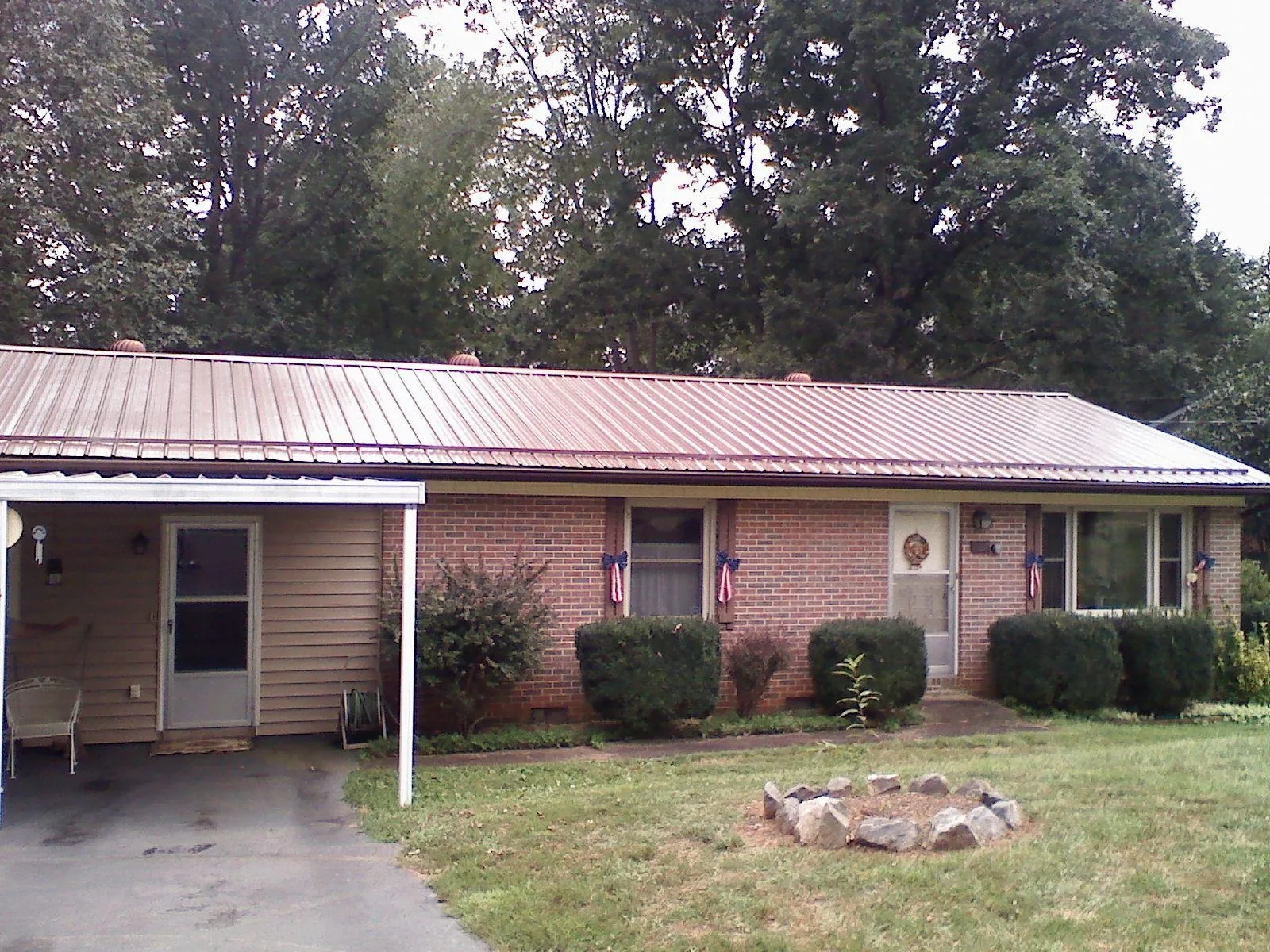 Bronze metal roof and carport on a brick ranch home — Roof Repair work by our crew in Cotati